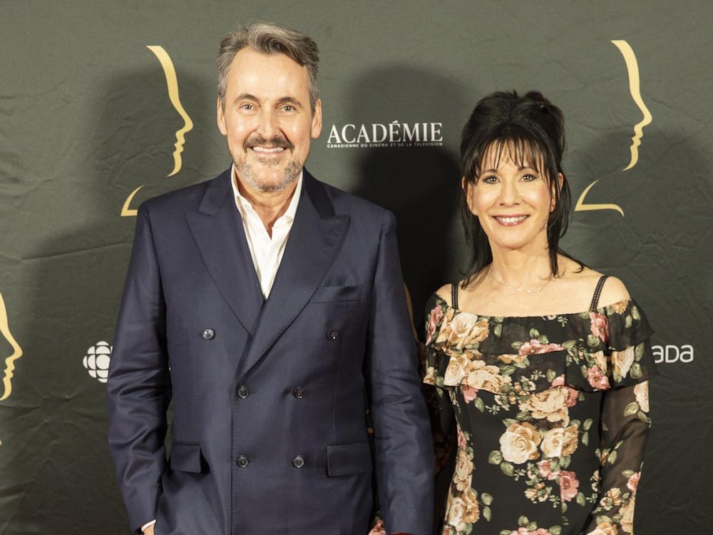 L'homme et la femme se tiennent la main   et sourient sur le tapis rouge. 