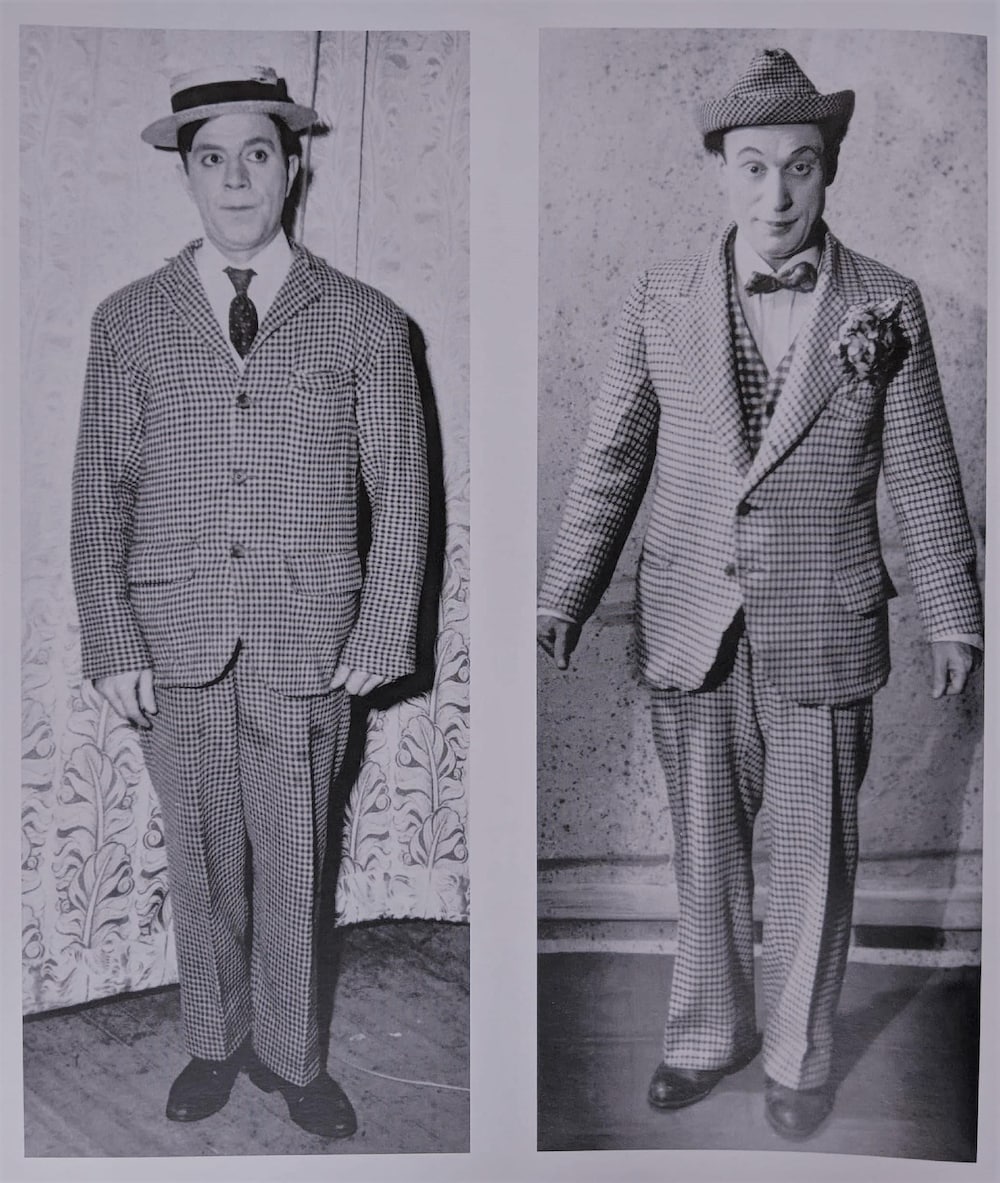 Les deux hommes sont habillés de manière similaire : un complet carotté, des souliers en cuir et un petit chapeau.