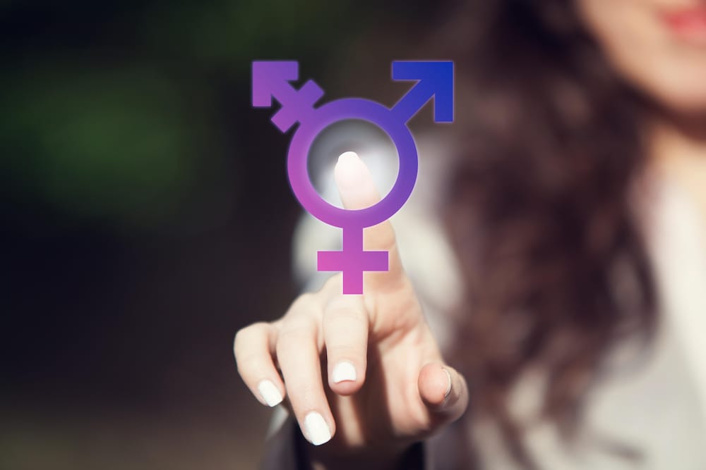Une femme met le doigt sur un symbole représentant les différentes orientations sexuelles.