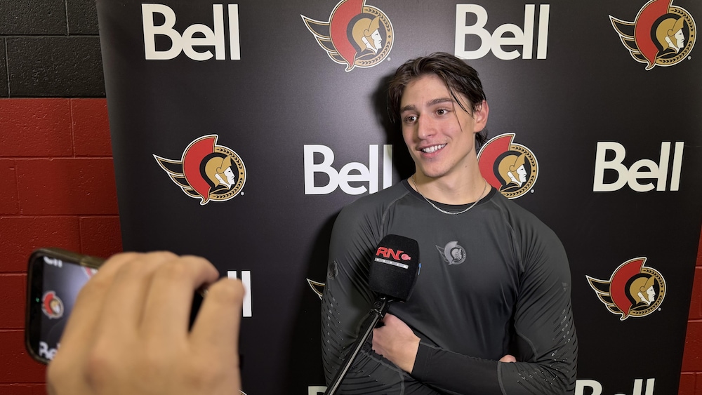 Un joueur de hockey répond aux questions des journalistes. 