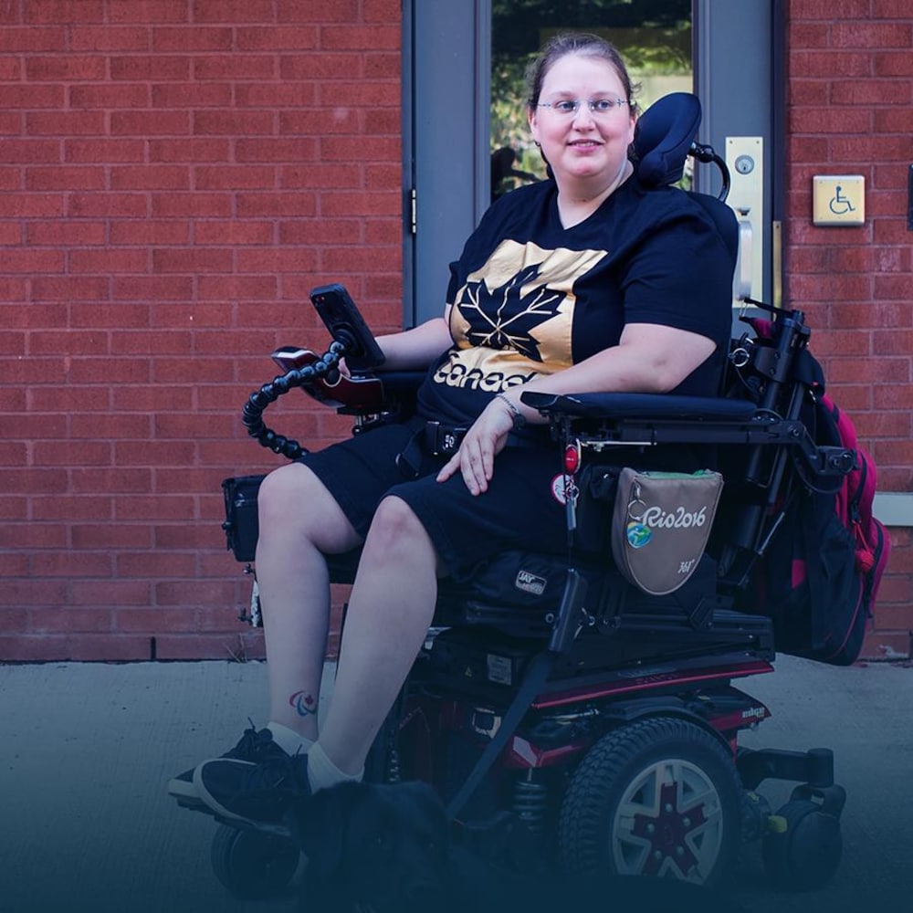 Alison Levine est assise dans son fauteuil roulant devant sa résidence.
