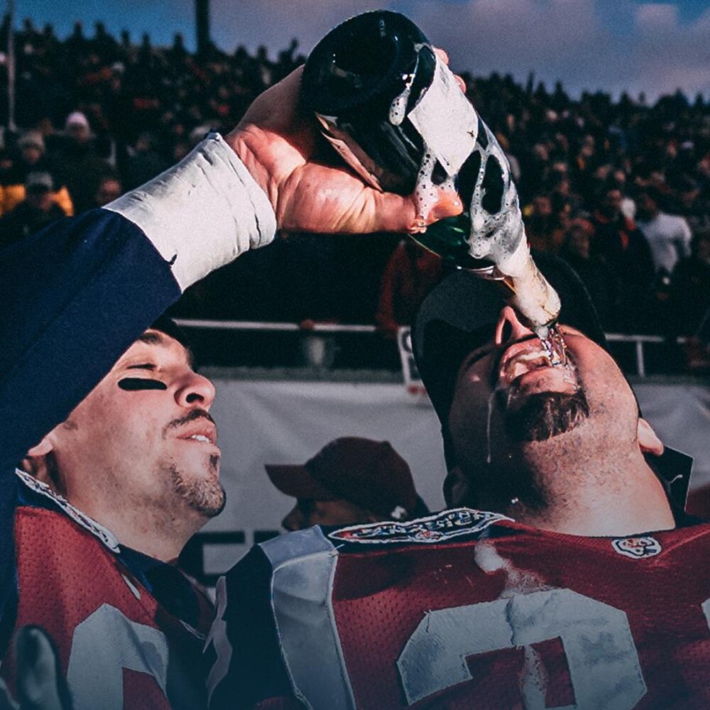 André Bolduc (gauche), des Alouettes, verse du champagne dans la bouche de son coéquipier et ami Bruno Heppell.