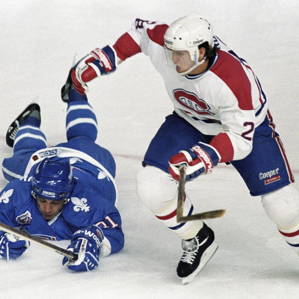 Valeri Kamensky, des Nordiques de Québec, tombe sur la glace en tentant de bloquer Éric Desjardins, du Canadien de Montréal.