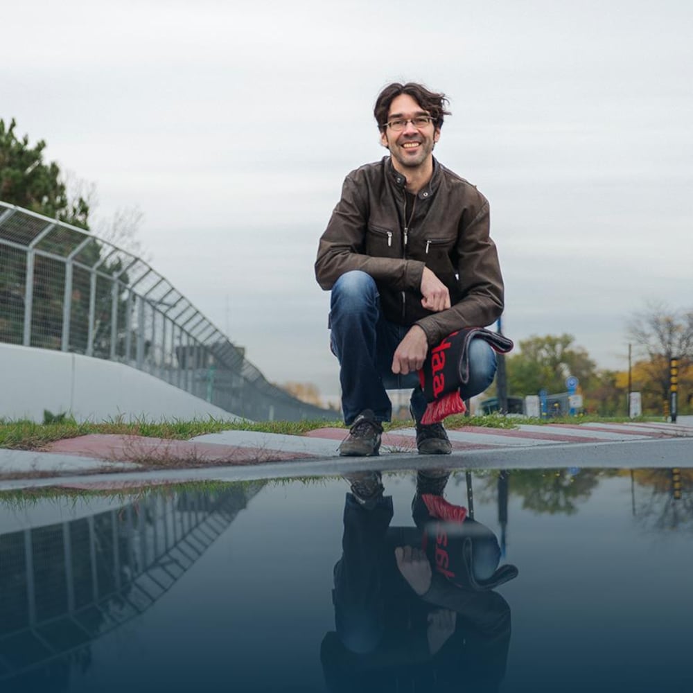 Le sujet est accroupi devant une flaque d'eau sur le circuit Gilles-Villeneuve à Montréal.