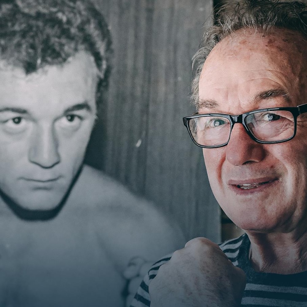 Fernand Marcotte pose devant une photo de lui à l'époque où il était boxeur.