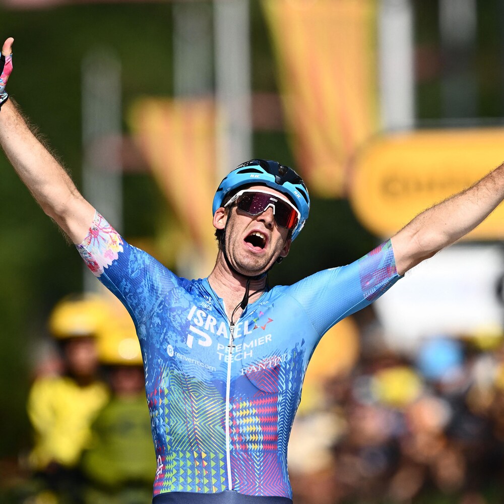 Le cycliste Hugo Houle lève les bras vers le ciel après sa victoire.