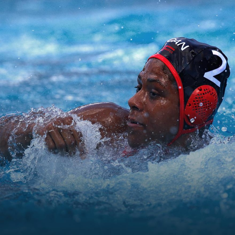 Une joueuse de water-polo regarde flotter un ballon.
