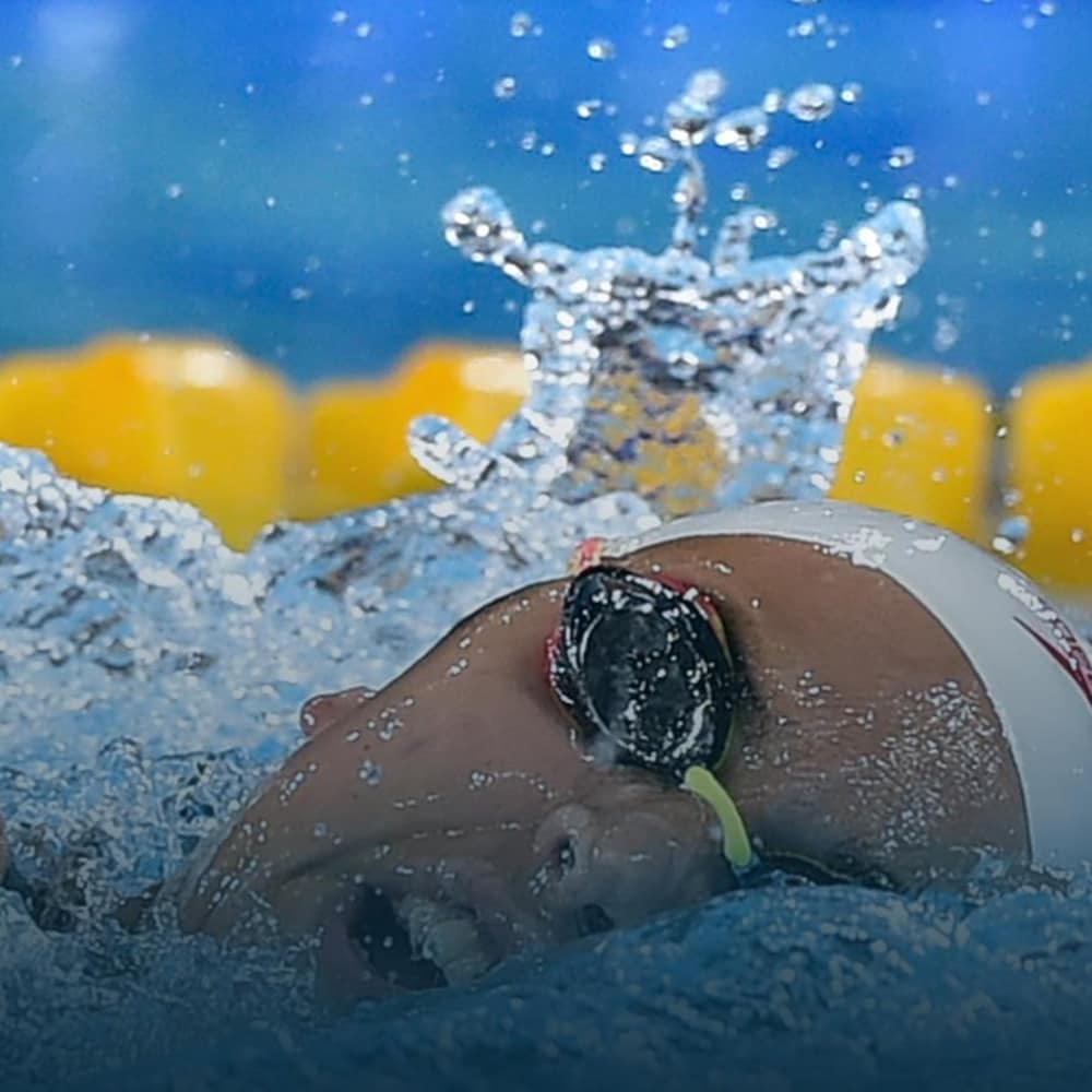 Une nageuse prend une respiration entre deux coups de bras.
