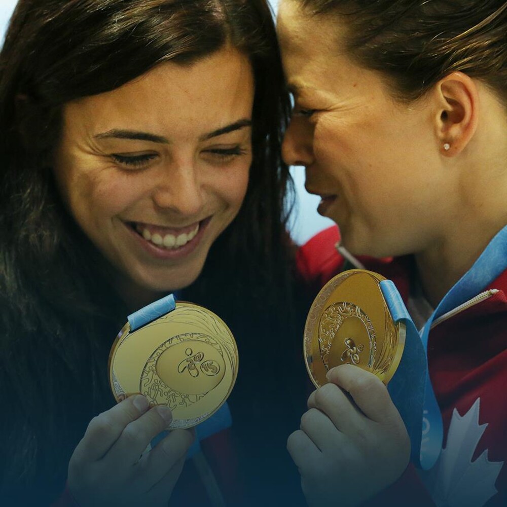 Deux jeunes femmes s'étreignent en montrant leurs médailles d'or.