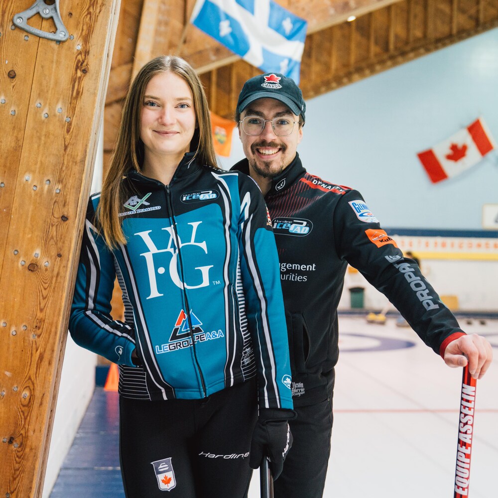 Un homme et une femme sourient près d'une glace de curling.
