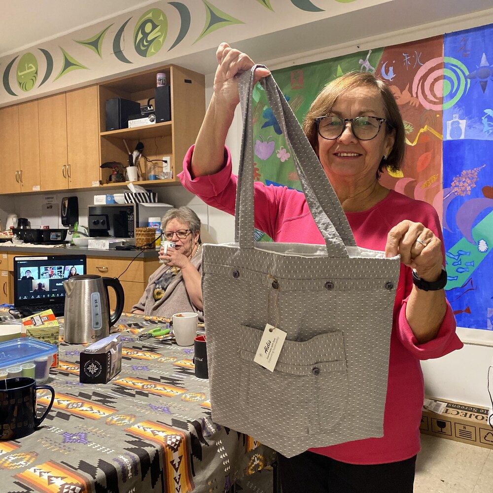 Une femme, Leonor, du groupe de femmes hispaniques de plus de 50 ans, les Alelís, pose avec l'un des sacs qu'elle a confectionné elle-même.