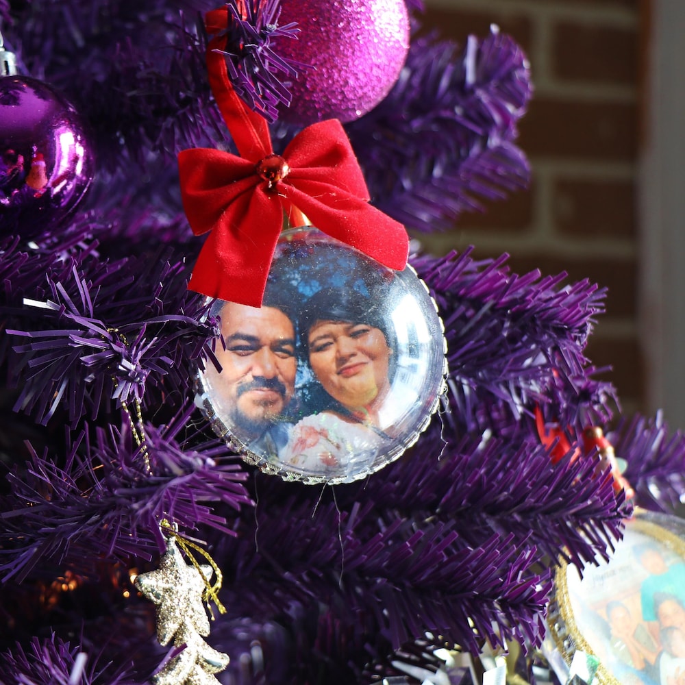 Un sapin mauve garni d'une boule de Noël où se trouve la photo de Joyce et de Carol.