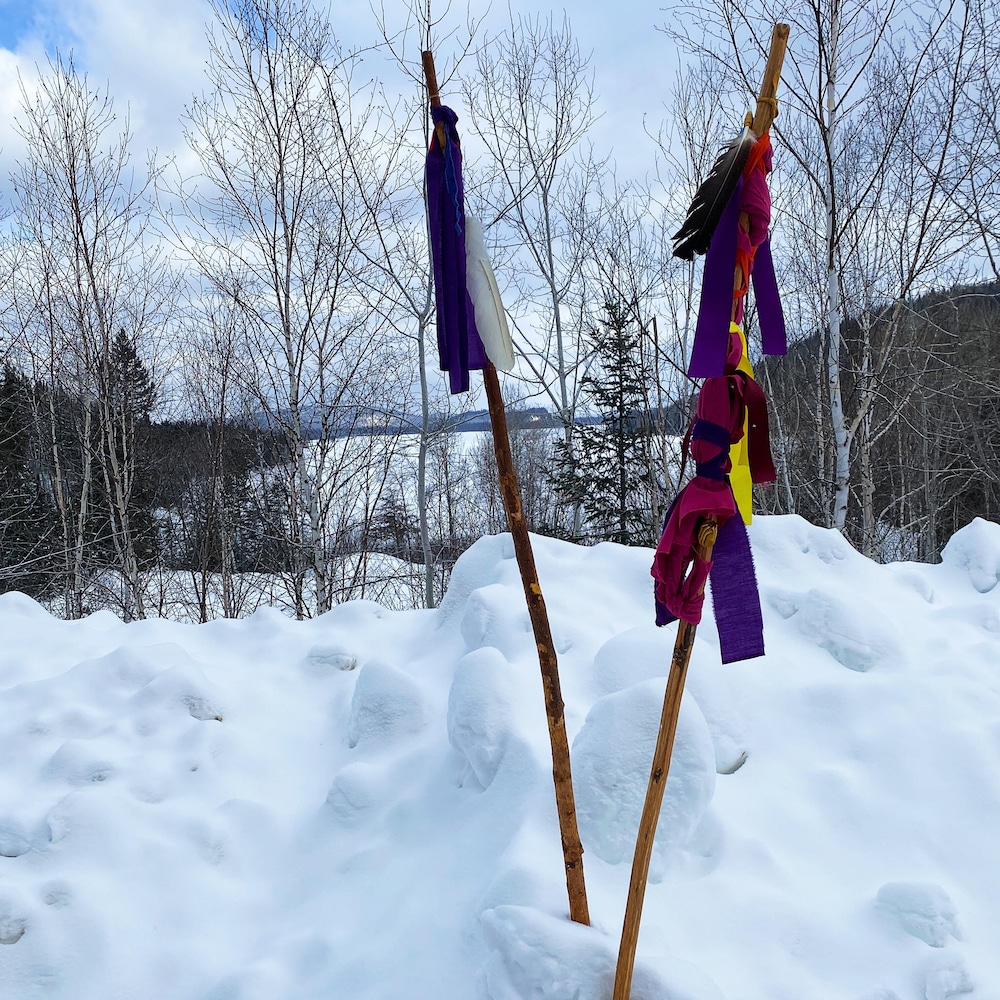 Un baton avec des rubans de couleurs, planté dans la neige