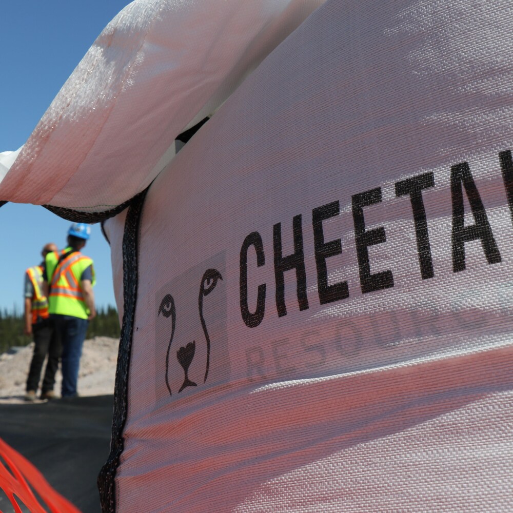 Un sac avec le nom de la compagnie Cheetah et en arrière-plan deux hommes