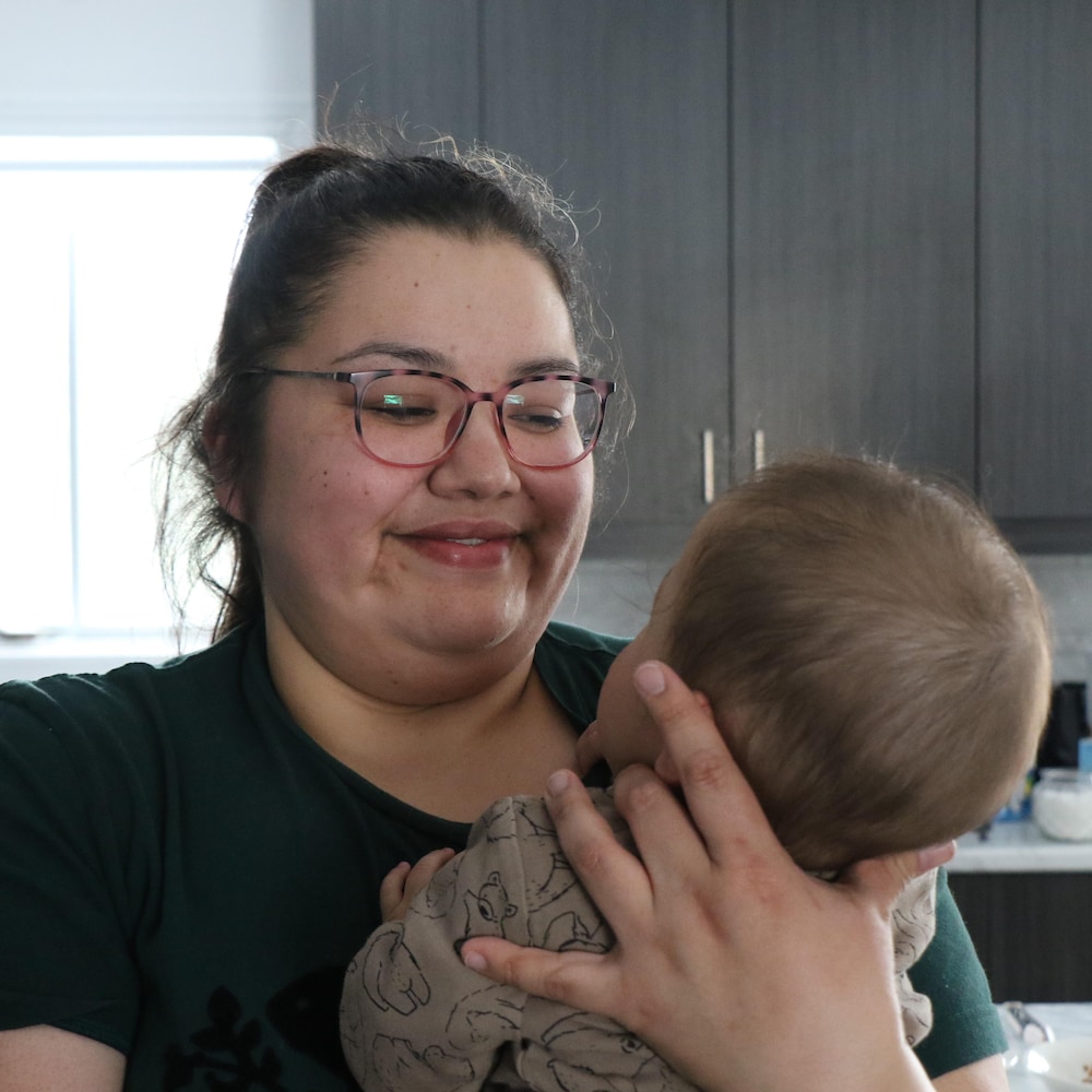 Shannon Chiskamish regarde un bébé dans ses bras.