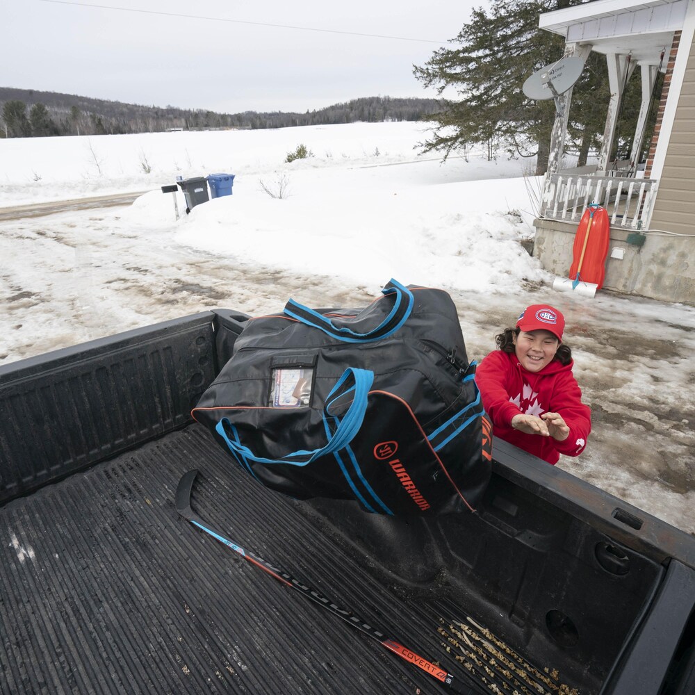 Washiiyeh Jeannotte lance un sac dans la caisse de la camionnette familiale.