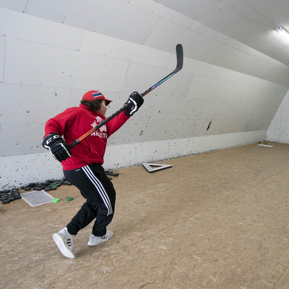 Washiiyeh Jeannotte pratique ses habiletés au hockey dans la grange familiale aménagée pour l'occasion.