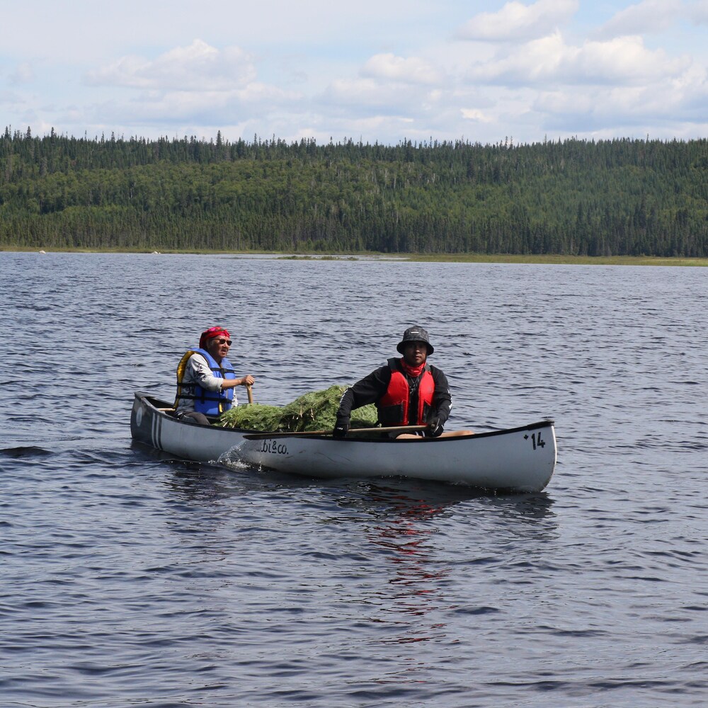 Un jeune homme et une aînée à bord d'un canot.