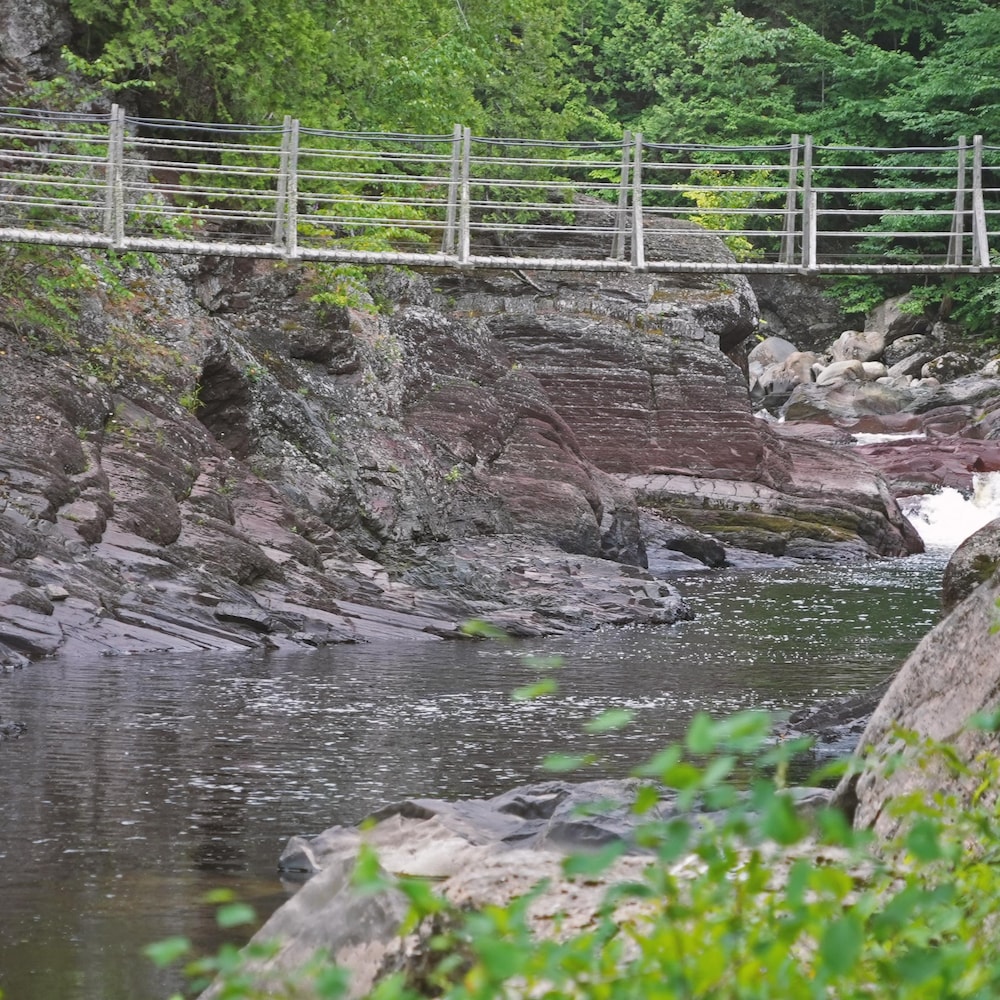 Une passerelle relie les parois rocheuses de la rivière Ouelle, dans le secteur de la fosse de La Cavée.
