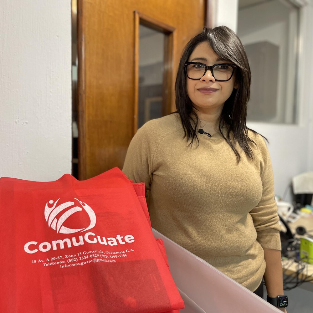 Estefania Pineda avec des sacs portant le logo de ComuGuate. 