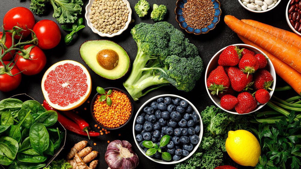 Table d'aliments sains remplie de fruits, de légumes et de légumineuses.