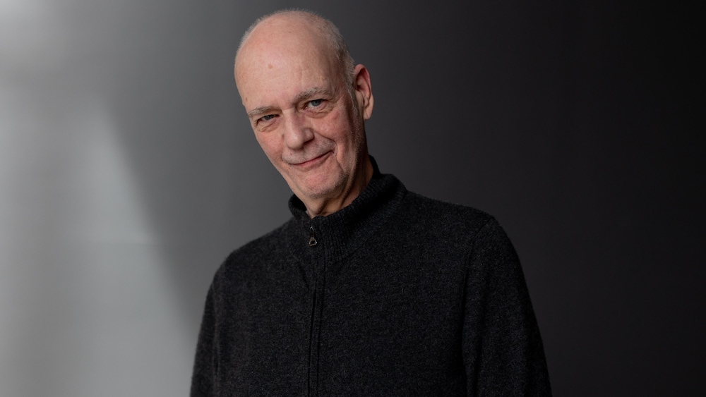 Il sourit au photographe.