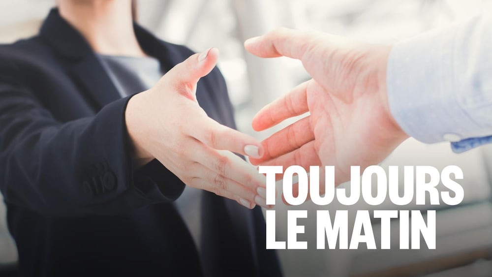 Une femme habillée en veston tend la main à un homme pour une poignée de main.