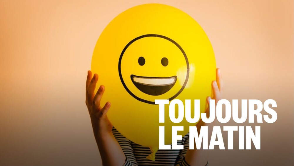 Une personne tient devant elle un ballon avec un bonhomme sourire.