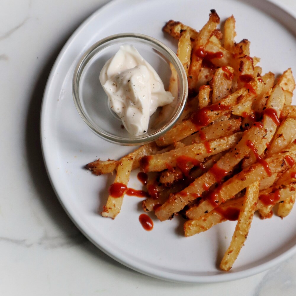 Des frites de chou-rave dans une assiette avec de la mayonnaise.