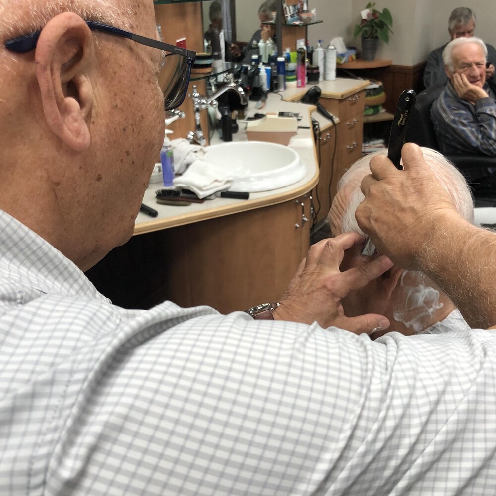 James Lynch coupant la barbe d'un client