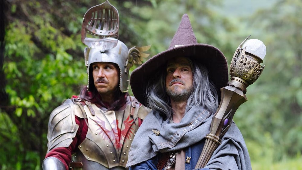 Deux hommes costumés en habits médiévaux de chevalier et de sorcier.