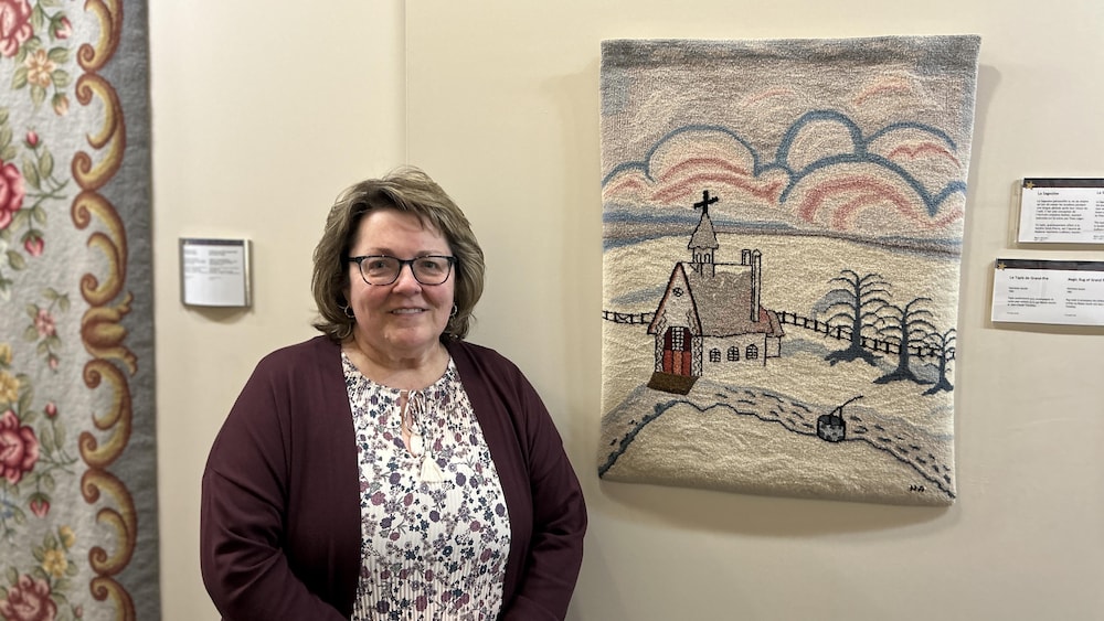 Une femme pose devant une œuvre d'art.