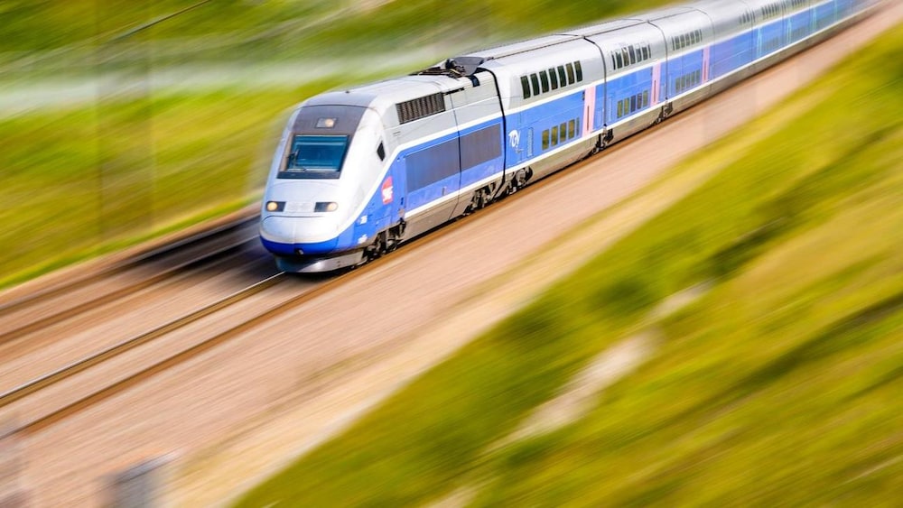 Un train à grande vitesse passe à travers un champ.