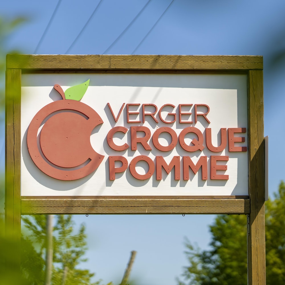 Une affiche en bois inscrit «Verger Croque Pomme