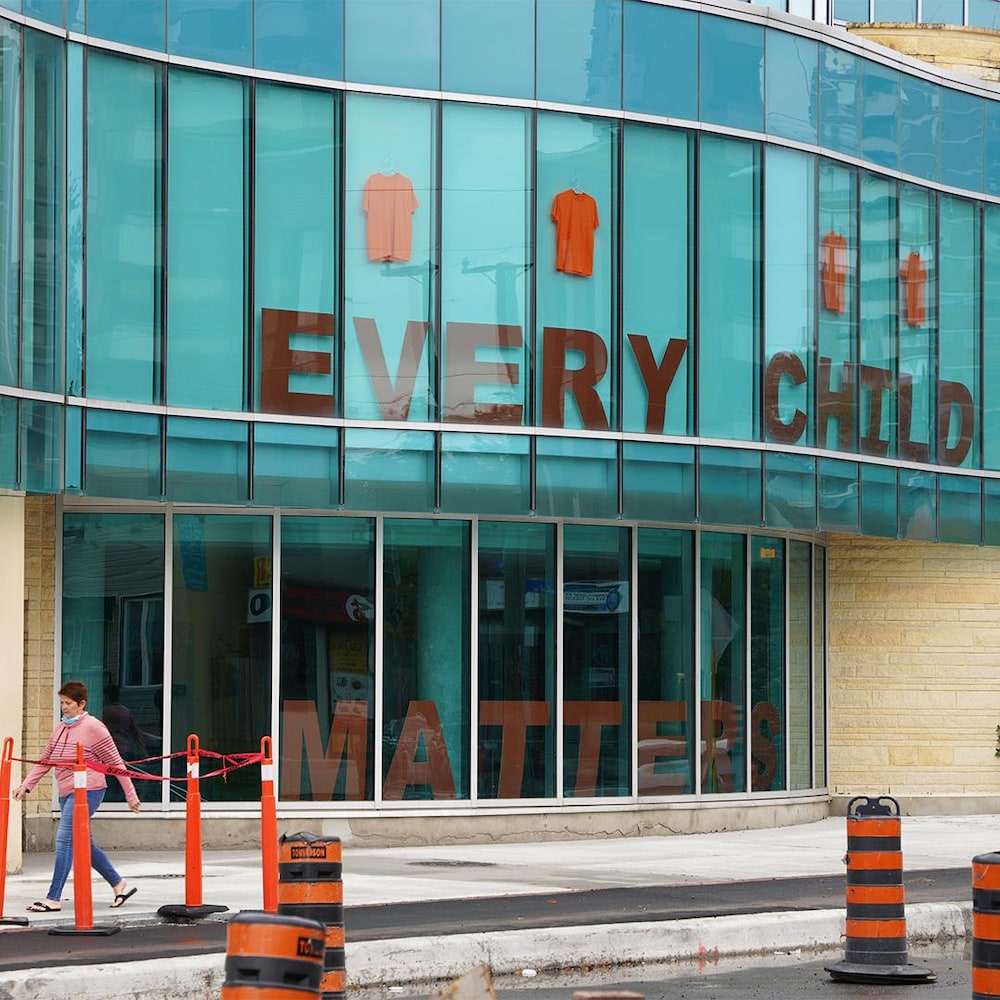 La devanture d'un édifice vitré où l'on peut voir la mention en grandes lettres : « Every child matters ».