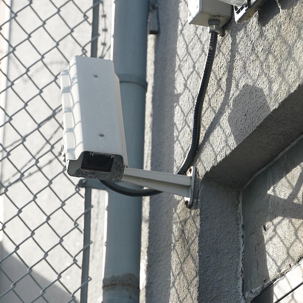 Une caméra de surveillance sur un mur d'un centre de détention.