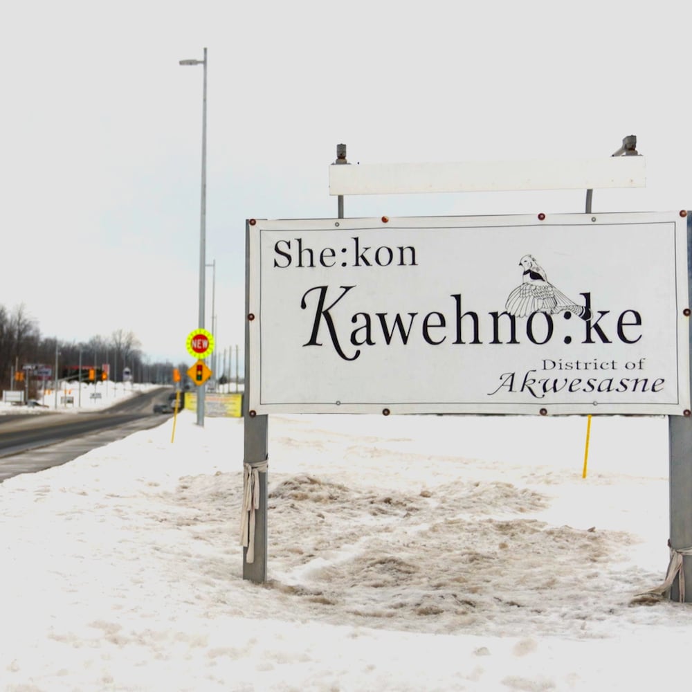 Une affiche indiquant Kawehnoke près d'une route.