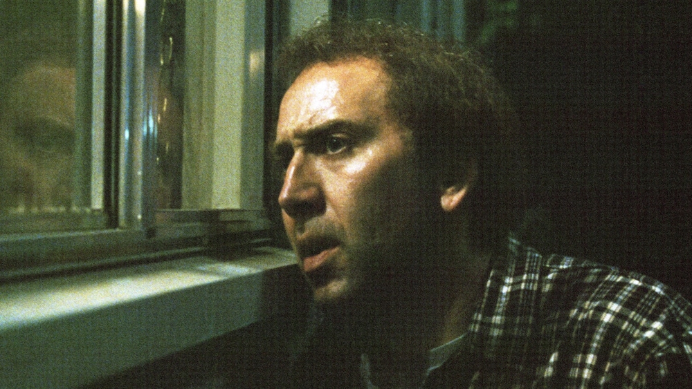 Sony Pictures Un homme à l'air inquiet regarde par la fenêtre.