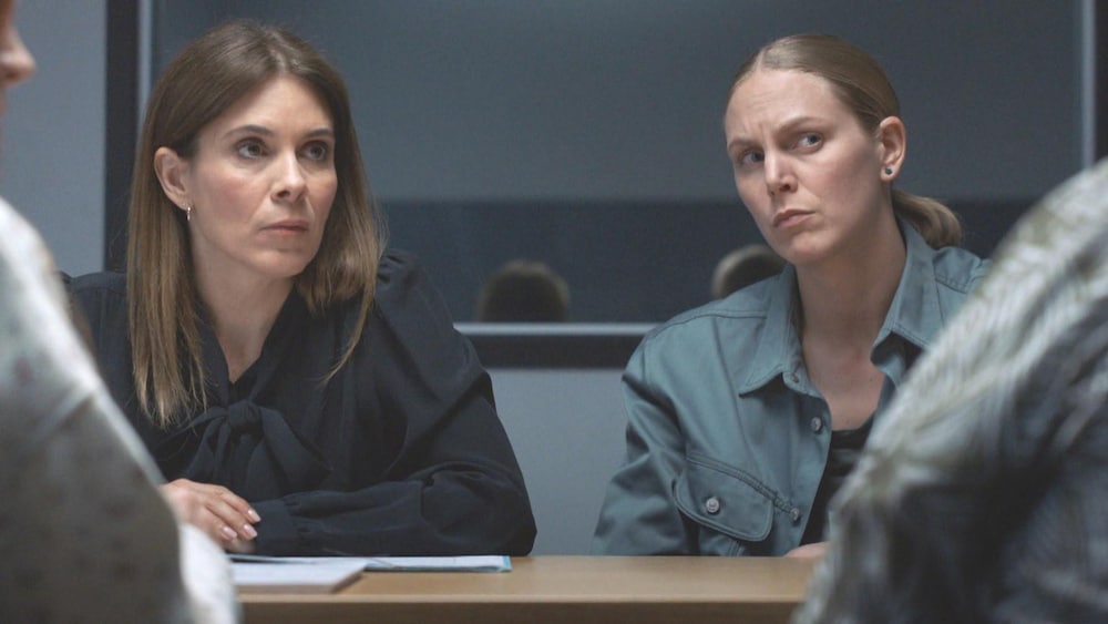 Deux femmes qui interrogent des personnes dans une salle d'interrogatoire.