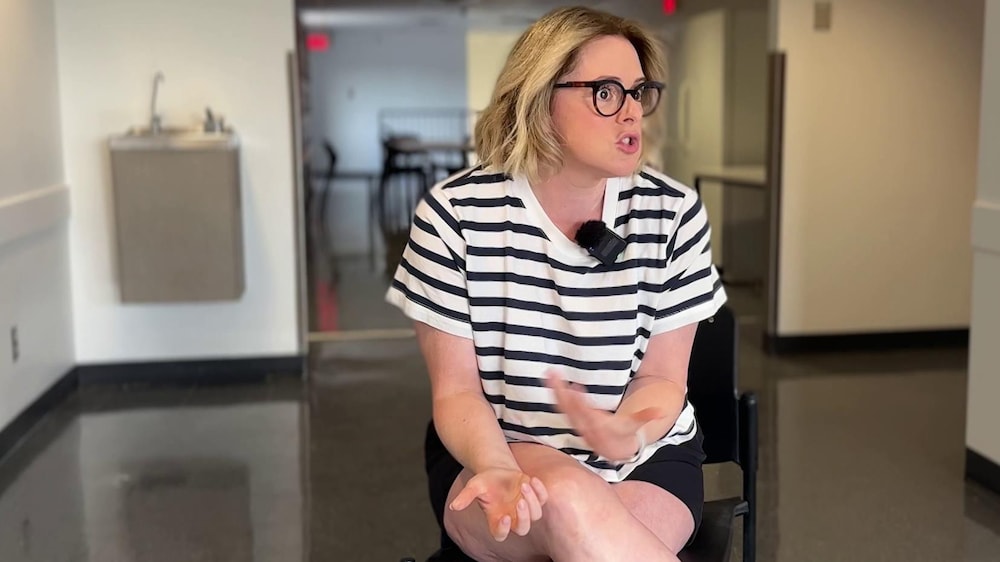 Mathilde est assise sur un tabouret et elle parle avec une personne devant elle.