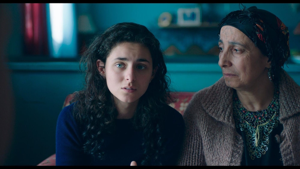 ACPAV Une jeune fille (Nahéma Ricci) assise à côté d'une positive vieille femme qui la regarde.
