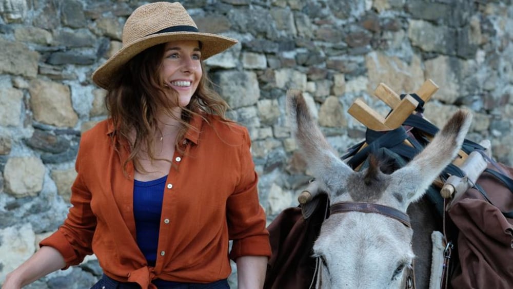 Axia Films Une femme (Laure Calamy) souriante tient un âne par une corde.