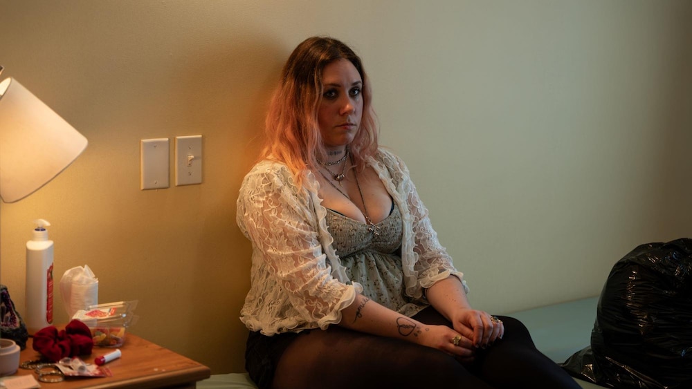 Radio-Canada Sandra (Ariel Charest) est assise sur son lit, dos au mur.