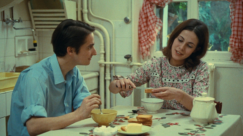 Un homme (Jean-Pierre Léaud) et une femme attablés devant des bols et des biscottes.