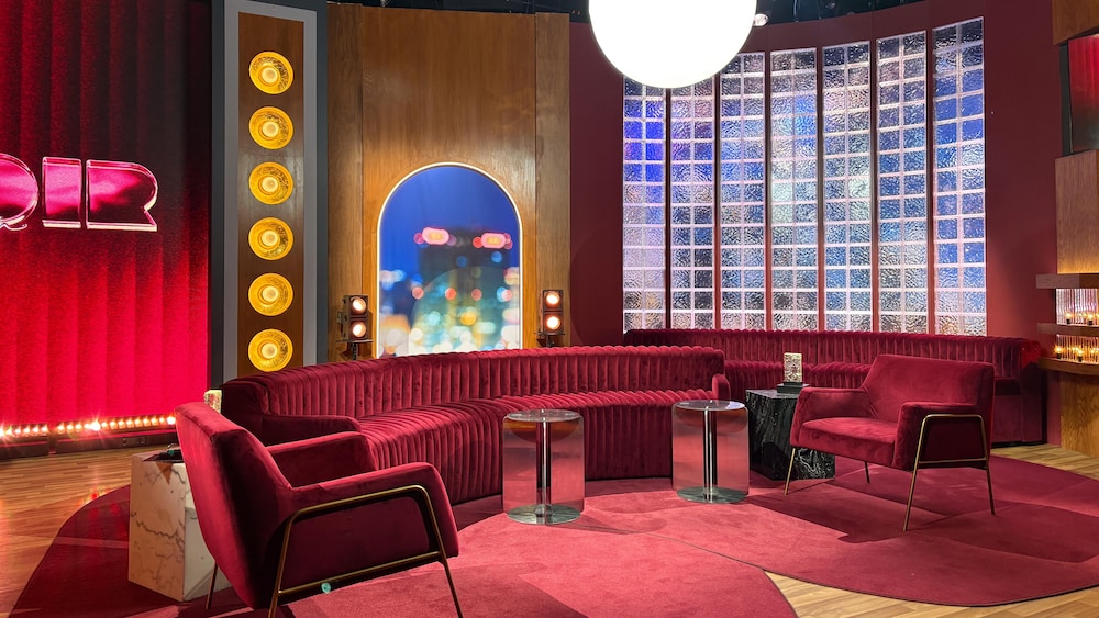 Un sofa de couleur prune avec des tapis forment le nouveau décor.