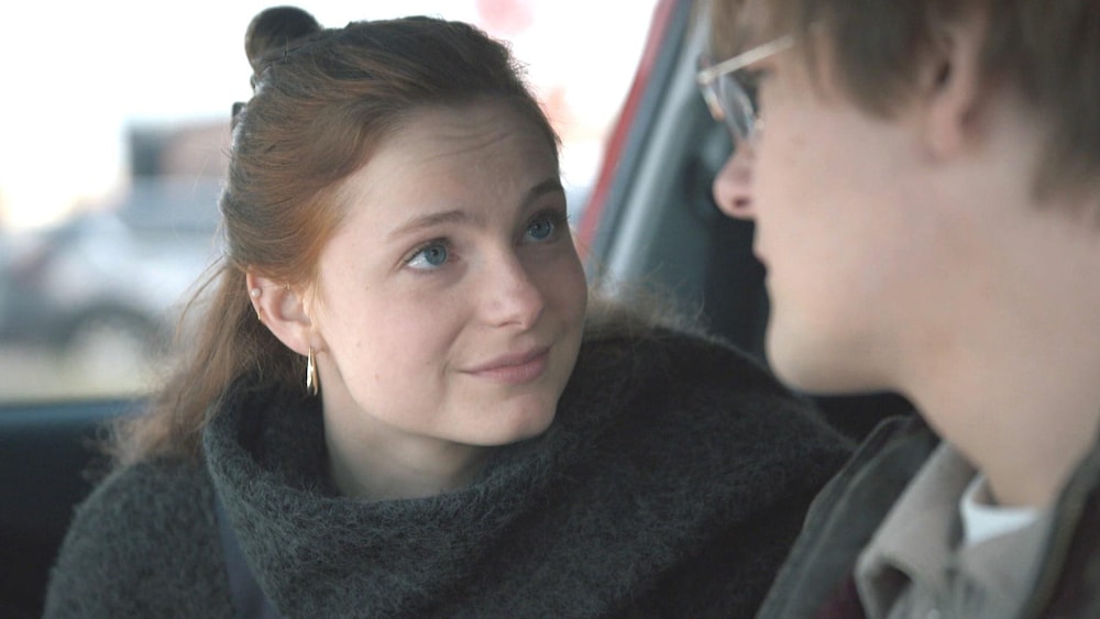 Une femme et un homme dans une voiture. Le couple se regarde.