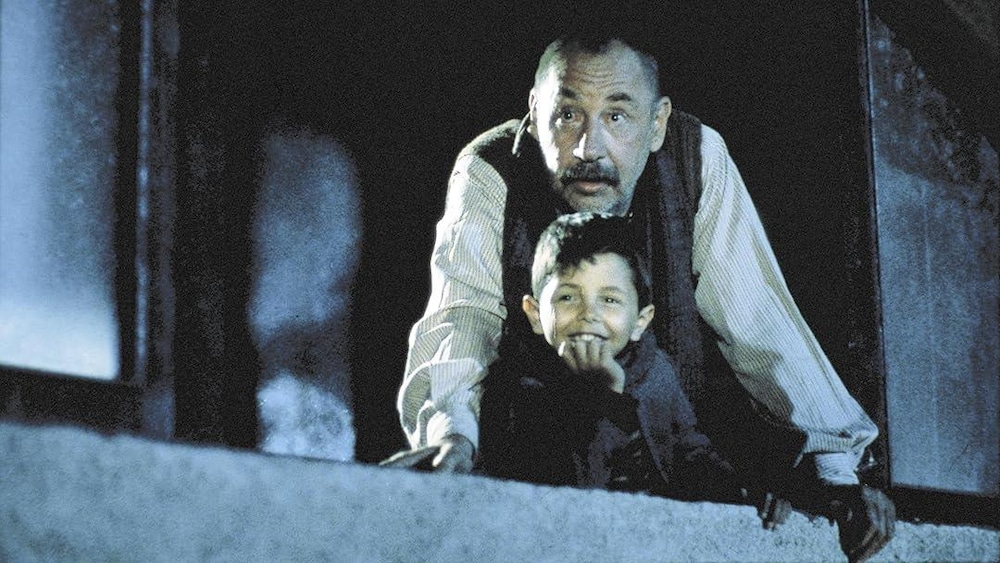 Un homme et un garçon regardent par une fenêtre.