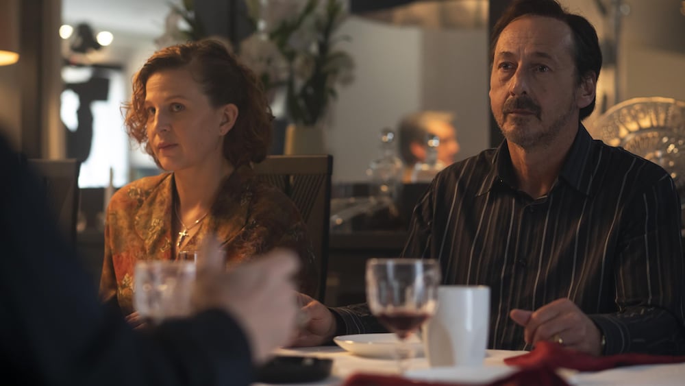 Un homme (Luc Picard) et une femme, côte à côte à table.