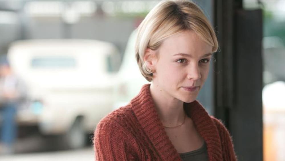 Alliance Vivafilm Une jeune femme blonde avec un gilet en laine rouge.