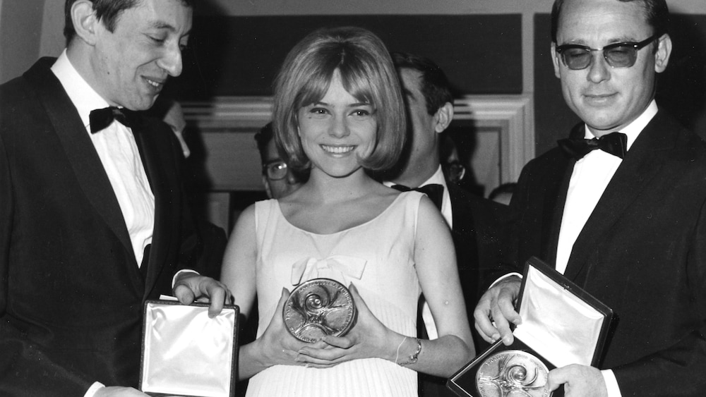 AP / Guilio Broglio Les trois personnes dont France Gall au centre tiennent une médaille dans la main.